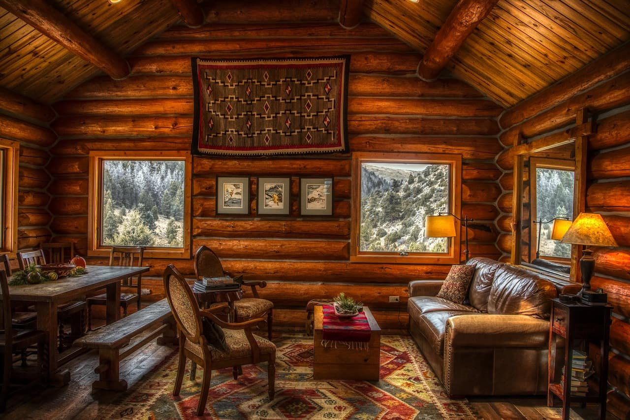Wohnbereich einer luxuriösen Blockhütte mit dunklen Möbeln und Teppichen.