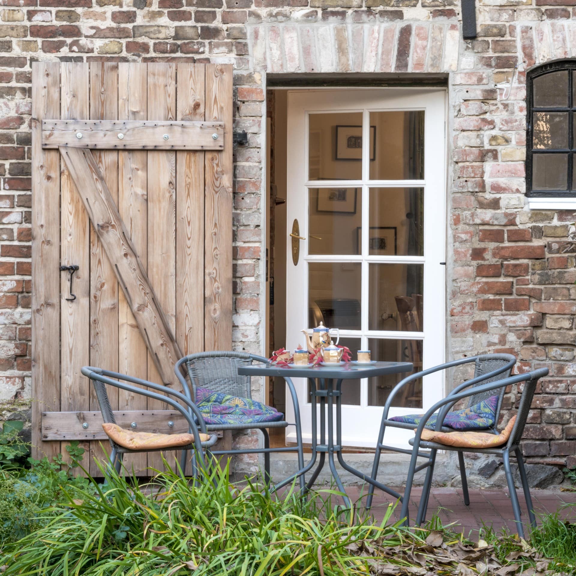 Terrasse mit Sitzgelegenheiten einer ländlich anmutenden Ferienwohnung in Berlin