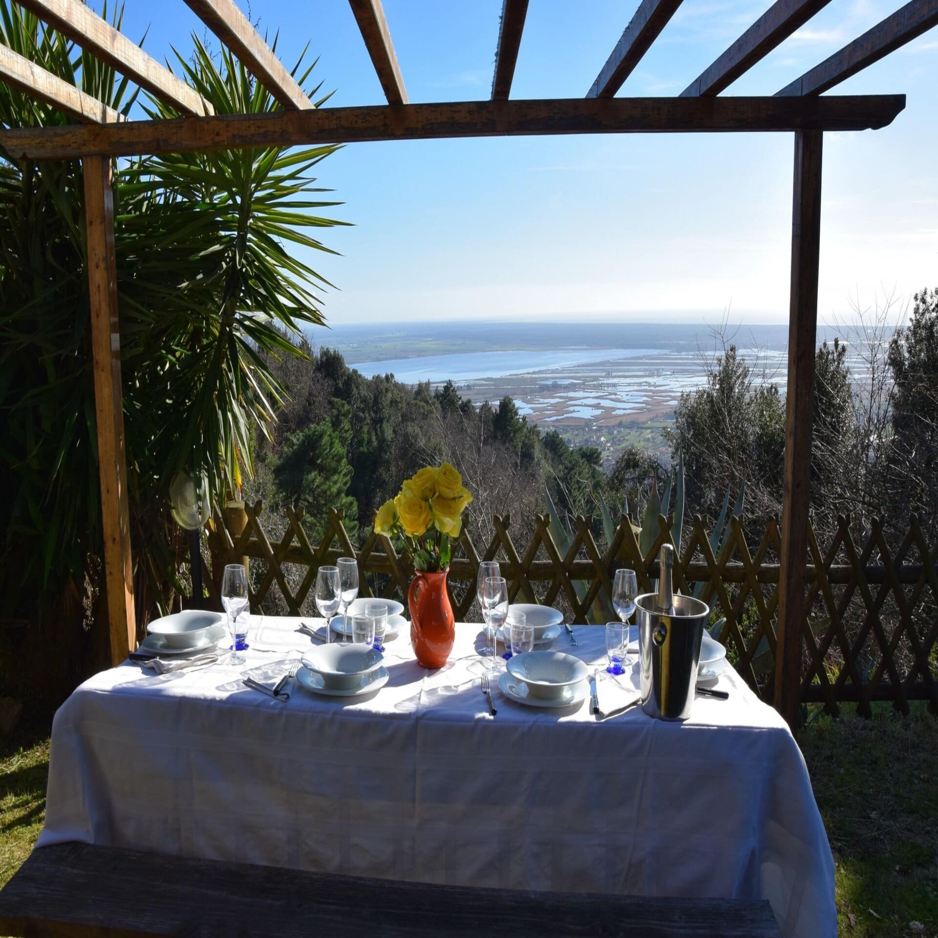 Gedeckter Tisch im Garten mit Blick auf das Meer.