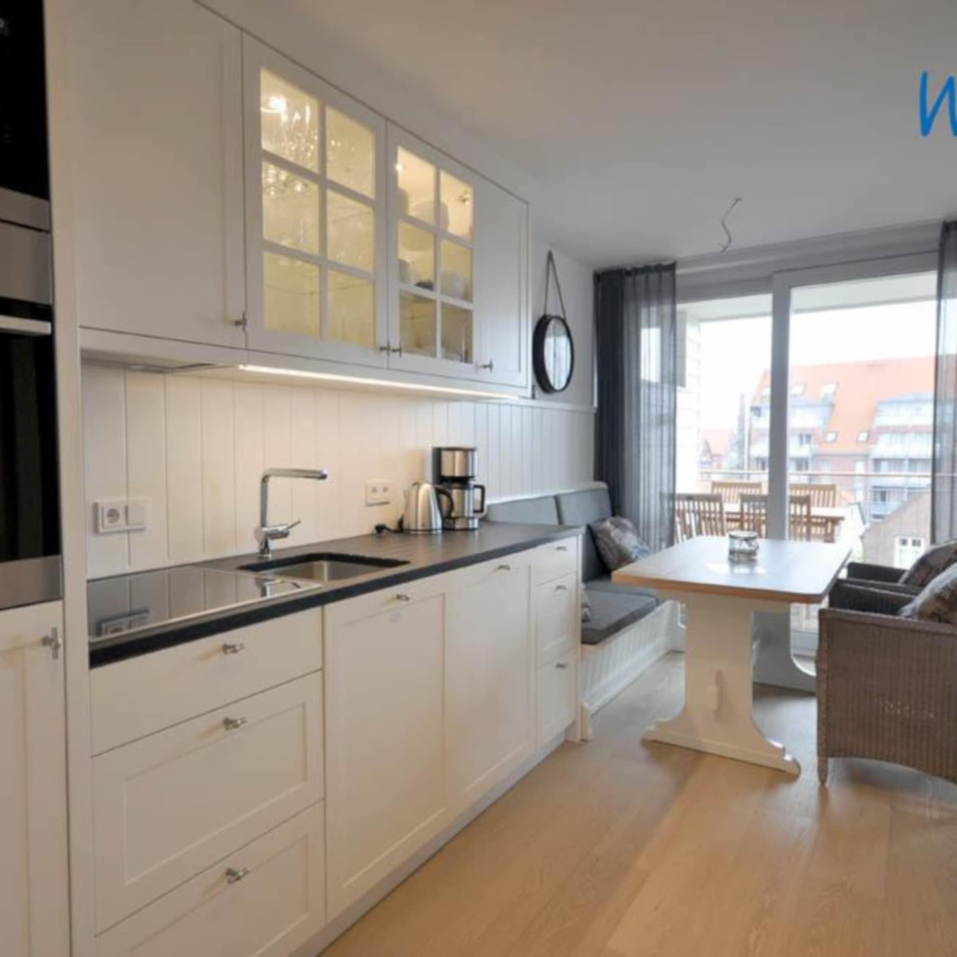 Moderne, helle Küche mit Esstisch und Balkon in einer Ferienwohnung auf Juist