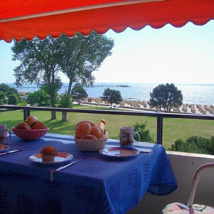 Gedeckter Frühstückstisch auf dem Balkon einer Ferienwohnung in Kellenhusen mit Blick auf Strand und Meer