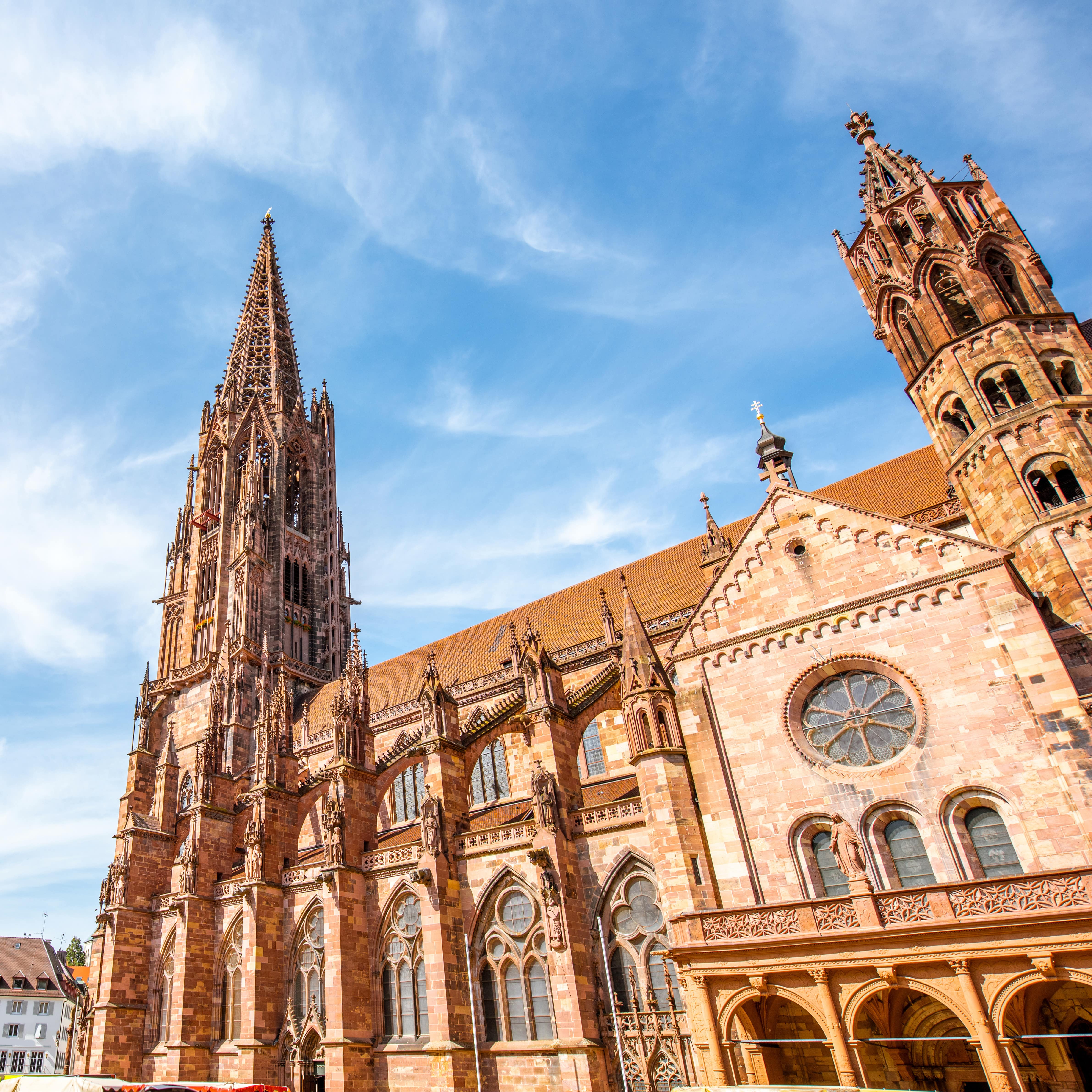 Blick von schräg unten auf das Freiburger Münster bei Sonnenschein.