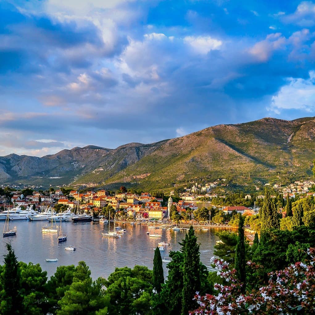 Panoramablick auf einen kleinen Ort an einer Bucht in Kroatien, im Wasser schwimmen Boote.