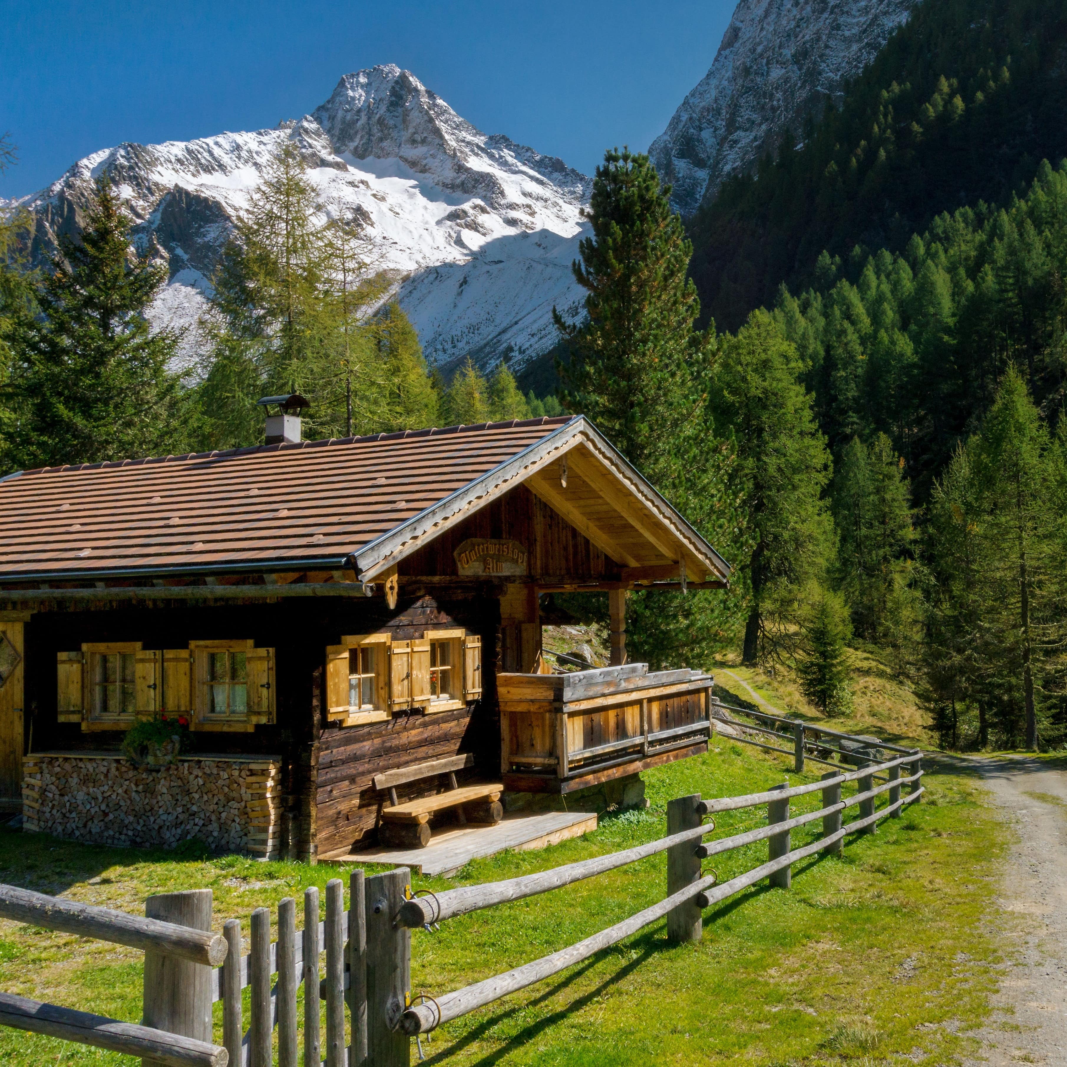 Gemütliche Holzhütte in Österreich vor einem mächtigen Berggipfel
