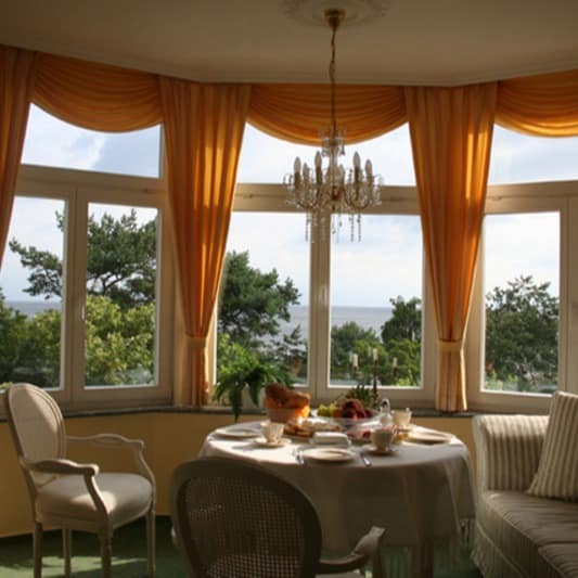 Ein Wohnzimmer mit Meerblick in einer Ferienwohnung in Ahlbeck, der Tisch ist gedeckt