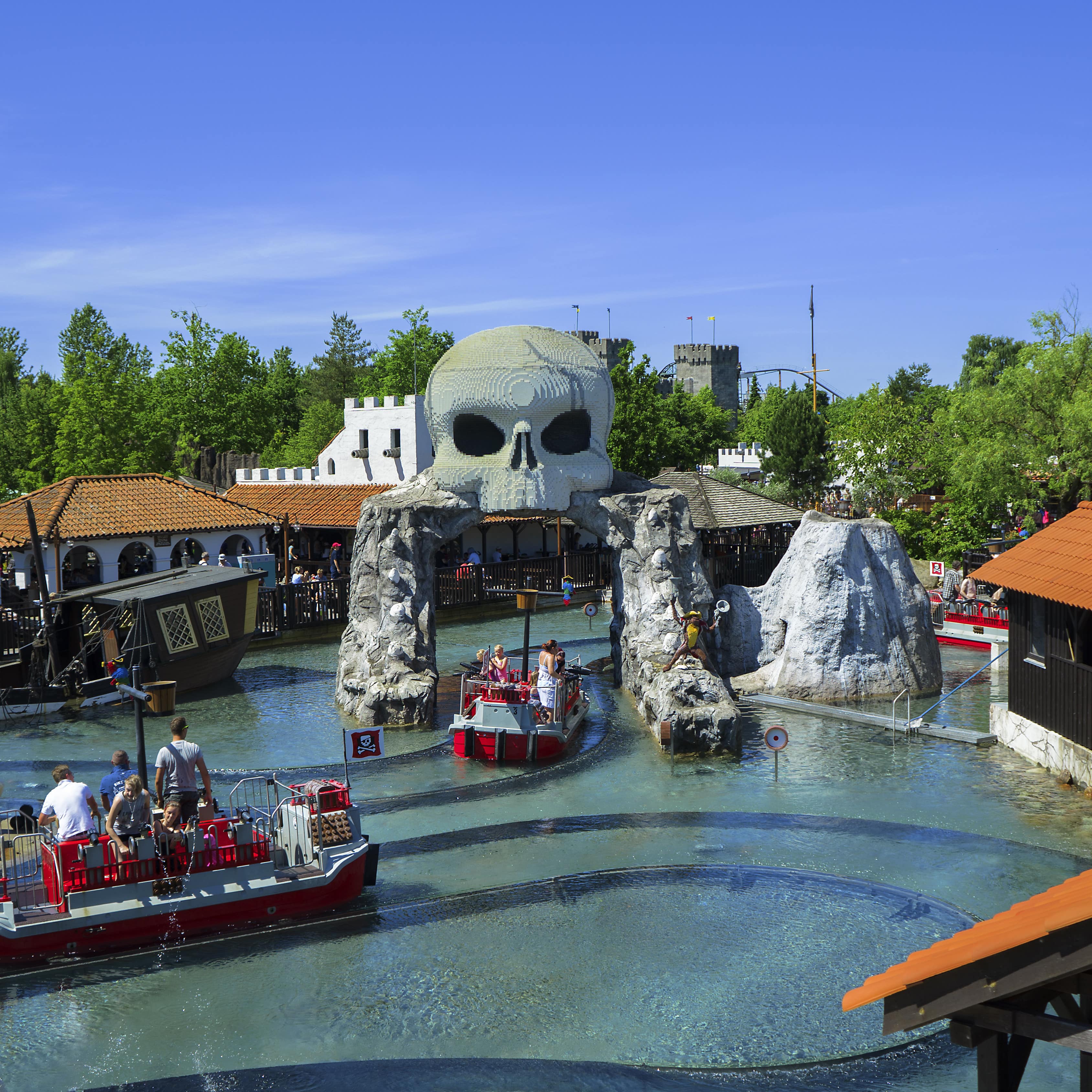 Blick über den Vergnügungspark in Billund, Boote mit Besuchern schippern durch eine Piratenlandschaft.