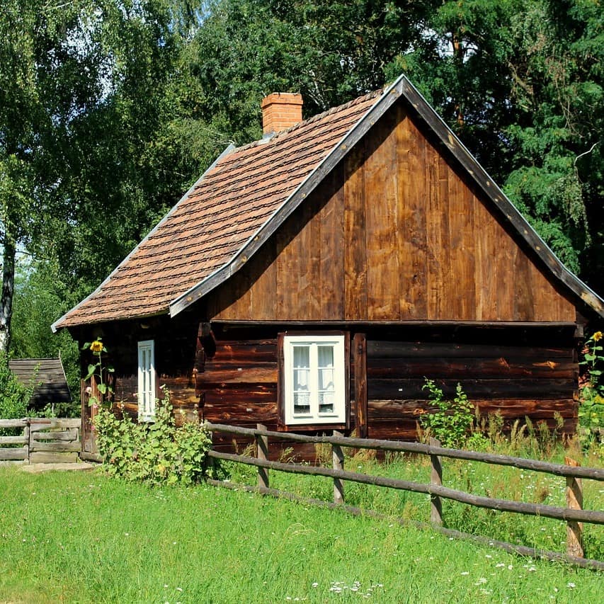 Eine Hütte mit Garten direkt am See und einem nebelverhangenen Berg