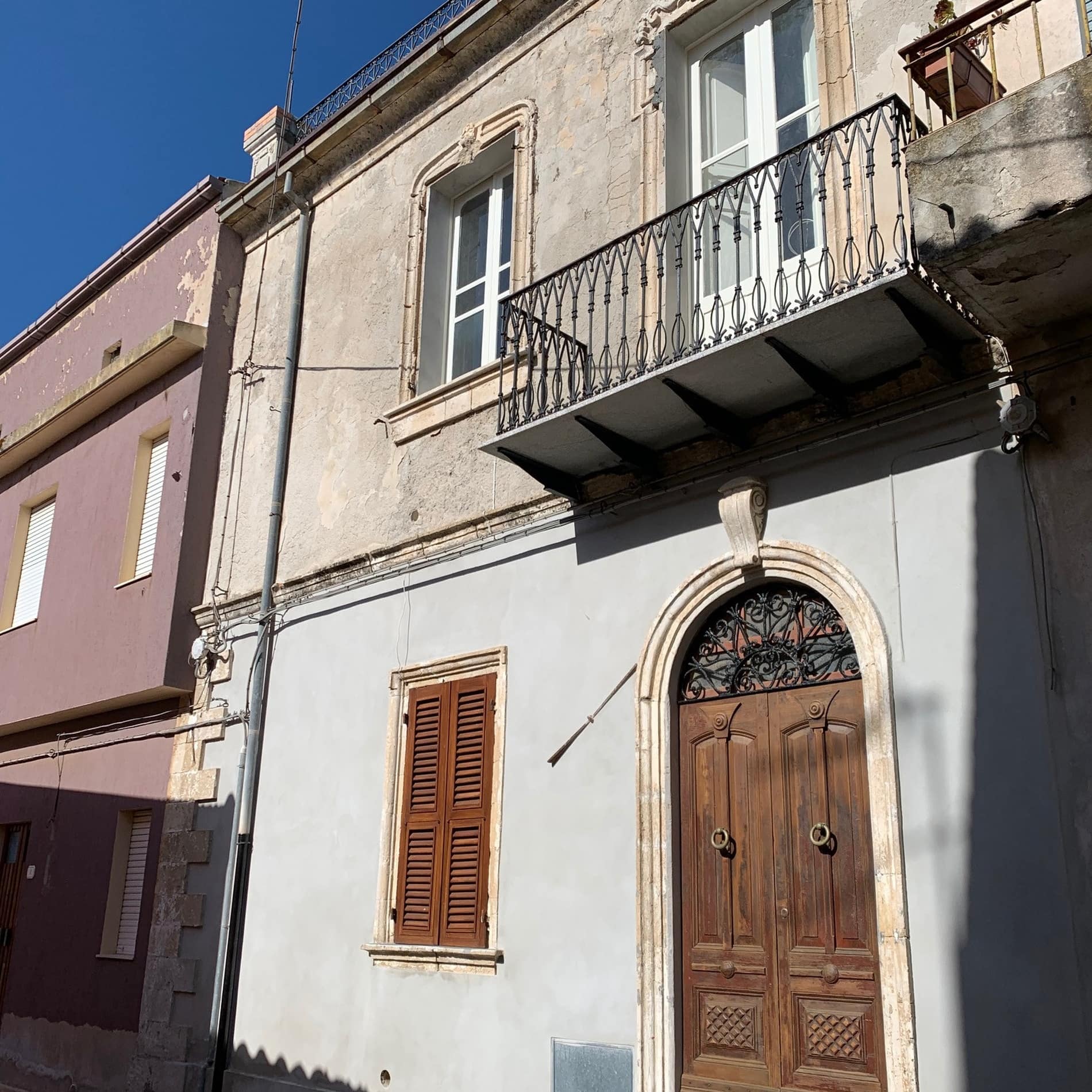 Fassade des Hauses aus dem 19. Jahrhundert in Pozzomaggiore, in dessen Obergeschoss eine Ferienwohnung zu mieten ist