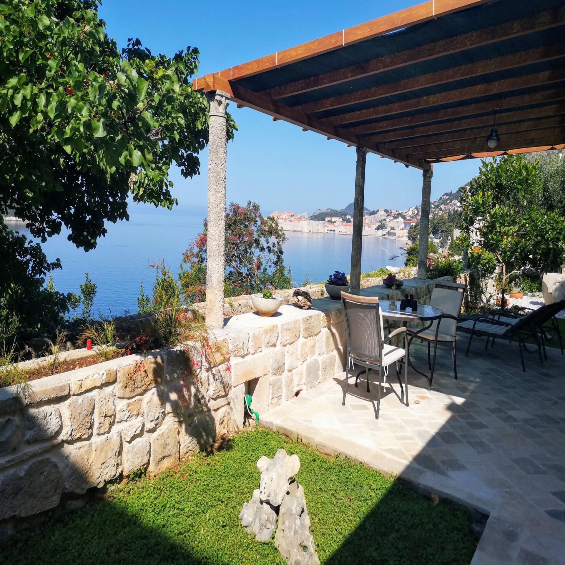 Garten mit Liegestühlen und Blick auf das Meer und eine Stadt in Kroatien.