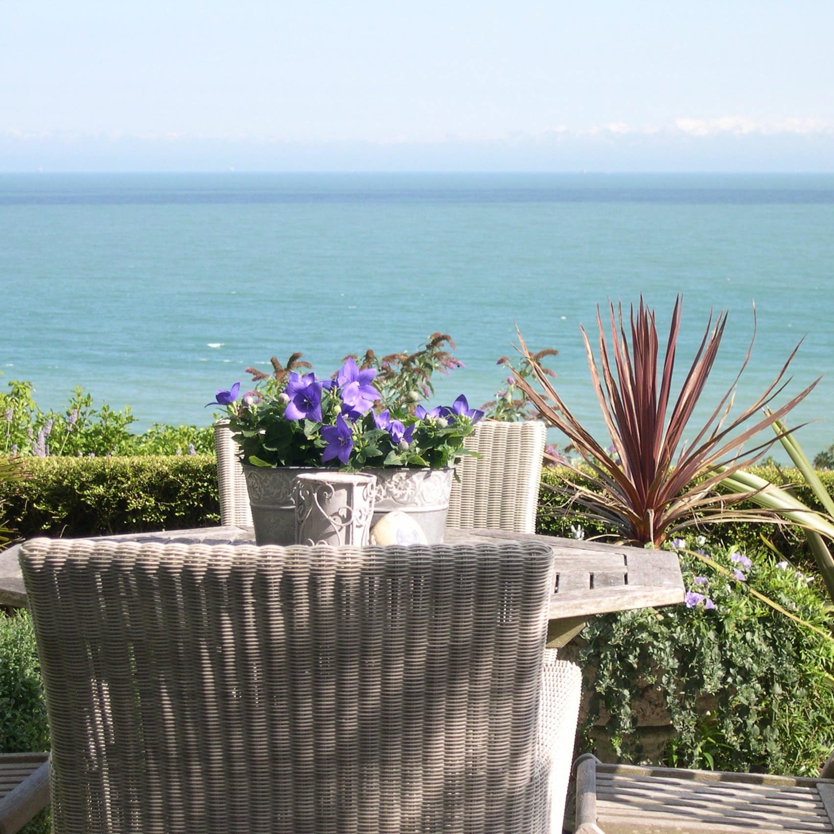 Blick vom Balkon mit Blumen einer Ferienwohnung an der Nordsee auf das Meer 