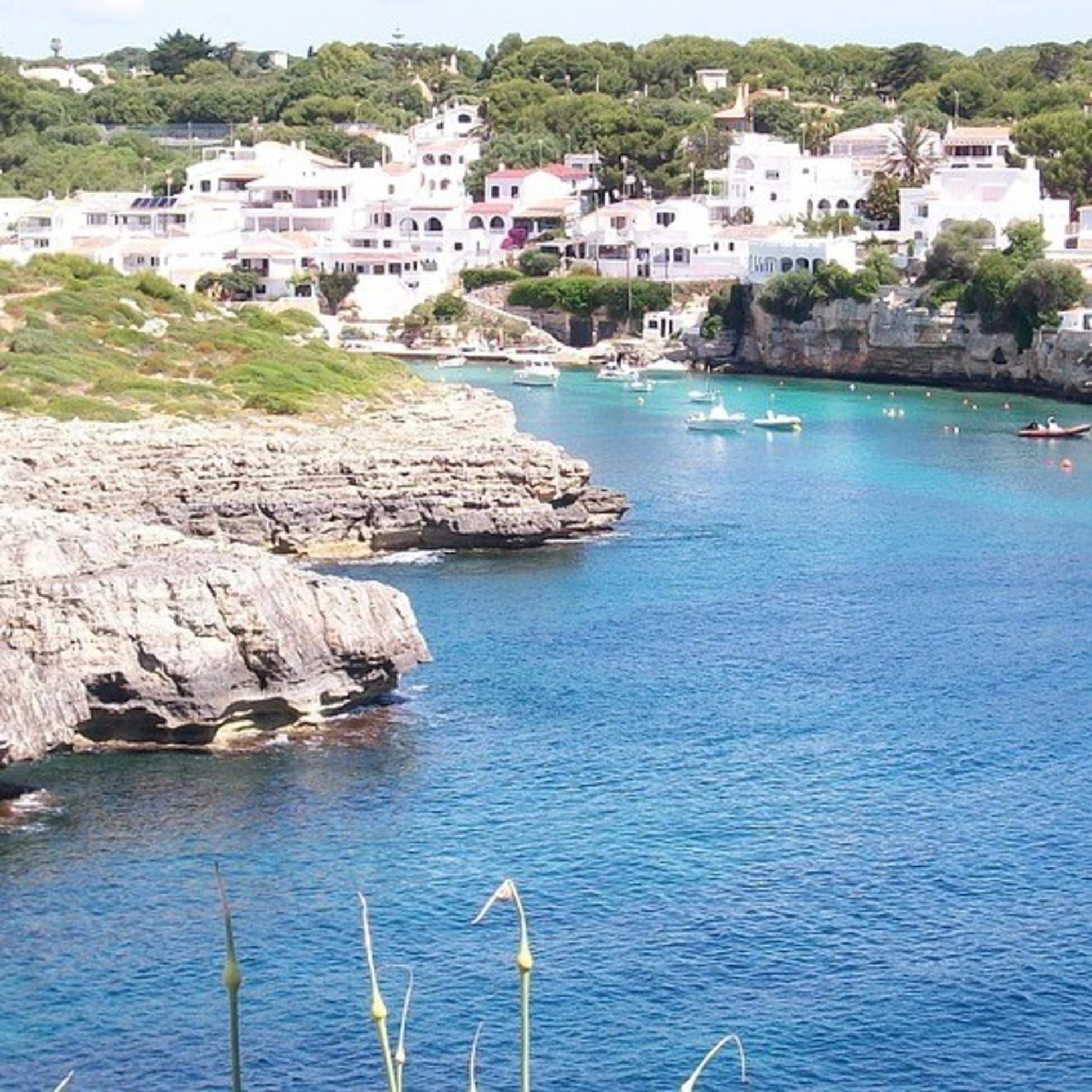 Die weißen Fincas auf Menorca mit Meerblick passen sich harmonisch in die Bucht ein
