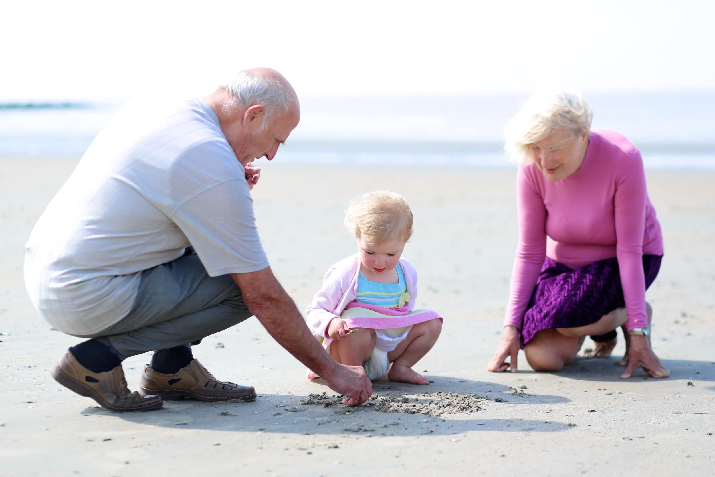 Großeltern am Strand mit einem Kleinkind
