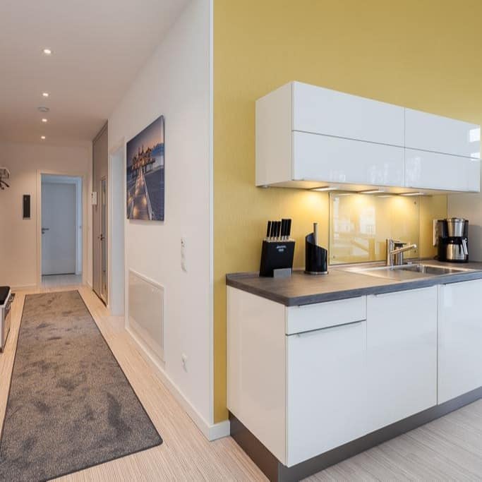 Küche und Flur einer modernen Luxus-Ferienwohnung bei Binz