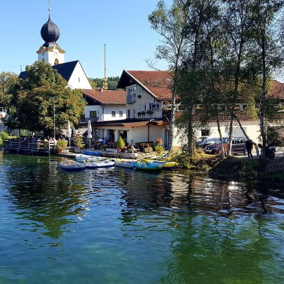 Pension am Chiemsee direkt am See und mit tollem Seeblick von den Zimmern, im Hintergrund eine Kirche