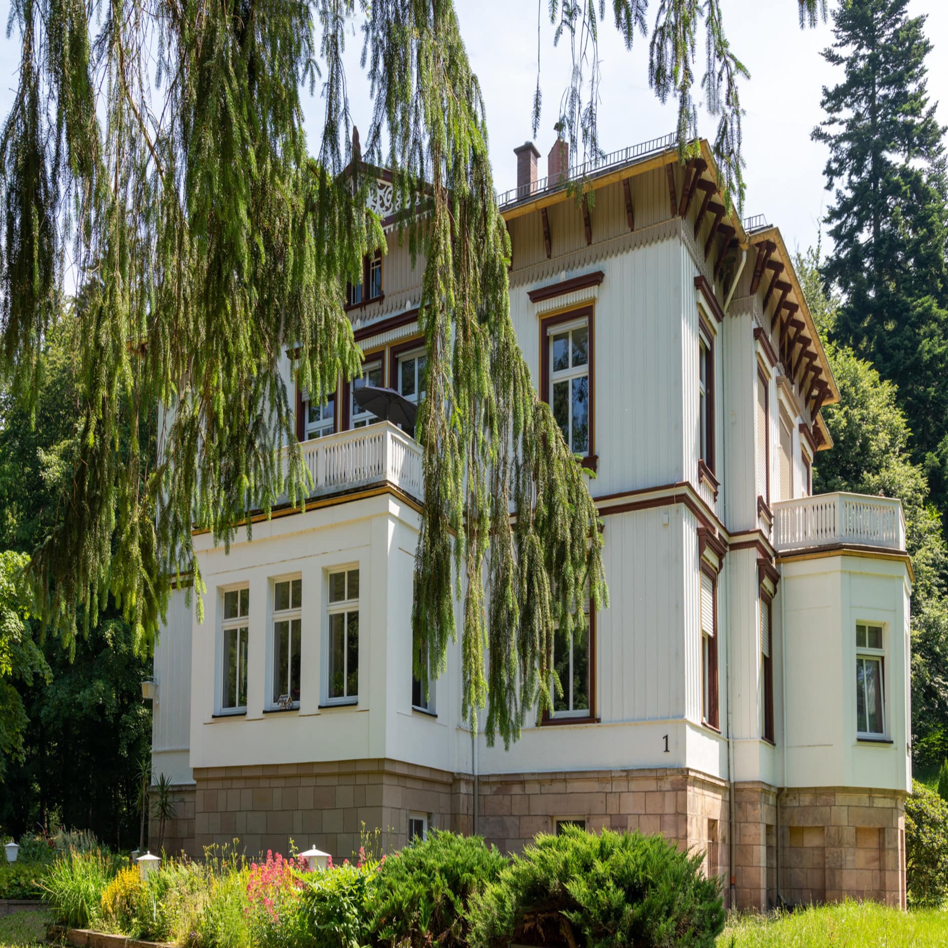 Villa mit Ferienwohnungen und einem gepflegten Garten.