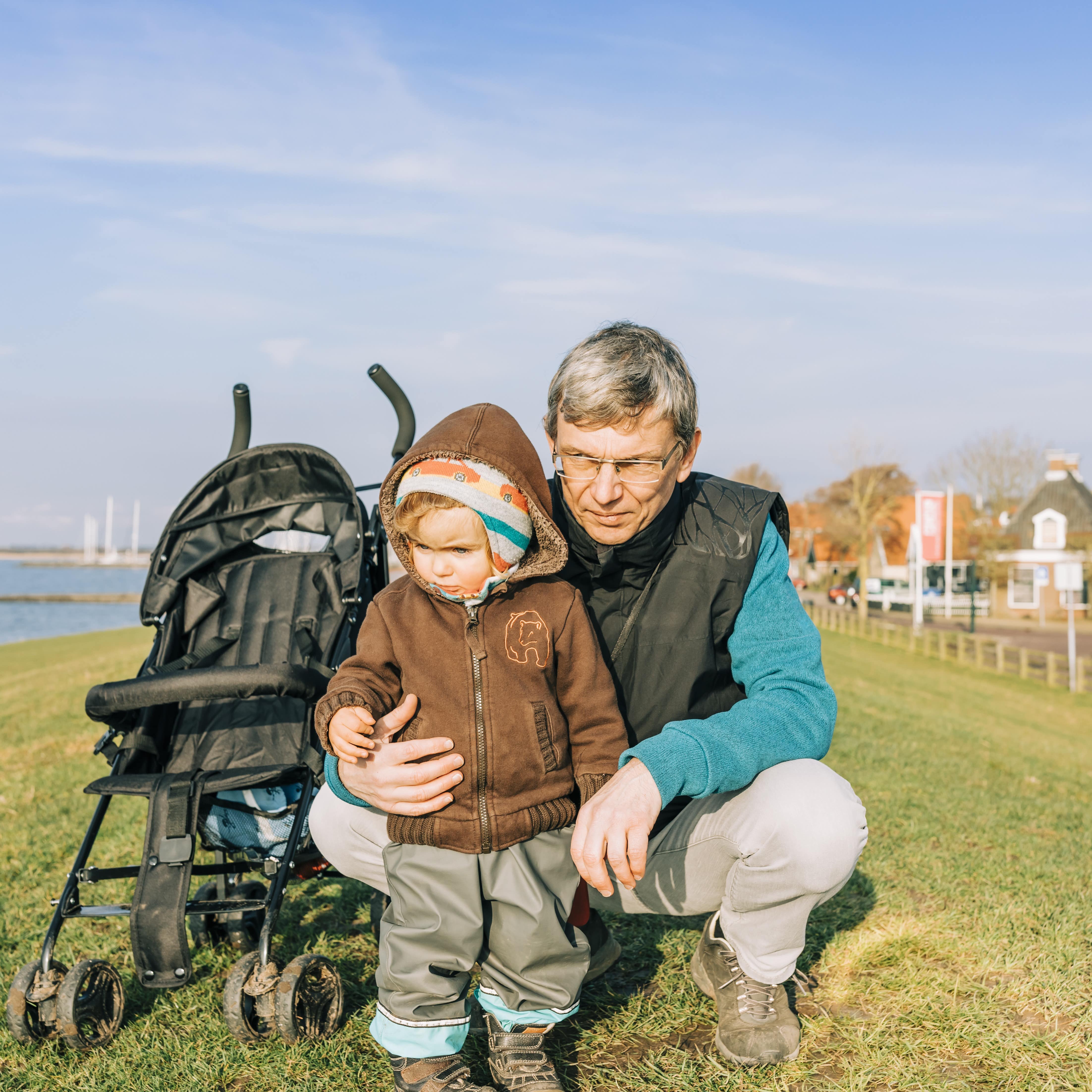 Ein Mann mit Kleinkind und Buggy auf einem Deich